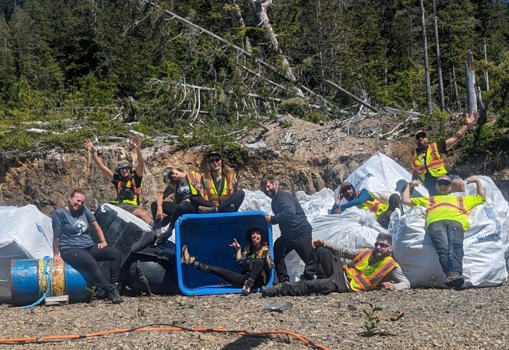 ocean legacy's beach cleanup team with tons of marine plastic debris we collected from a shoreline, posing with arms up, laying on supersacks and celebrating an ocean cleanup