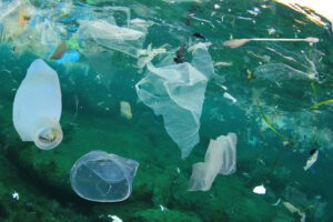 Plastic ocean pollution. Underwater bags, bottles, cups, straws and ear buds